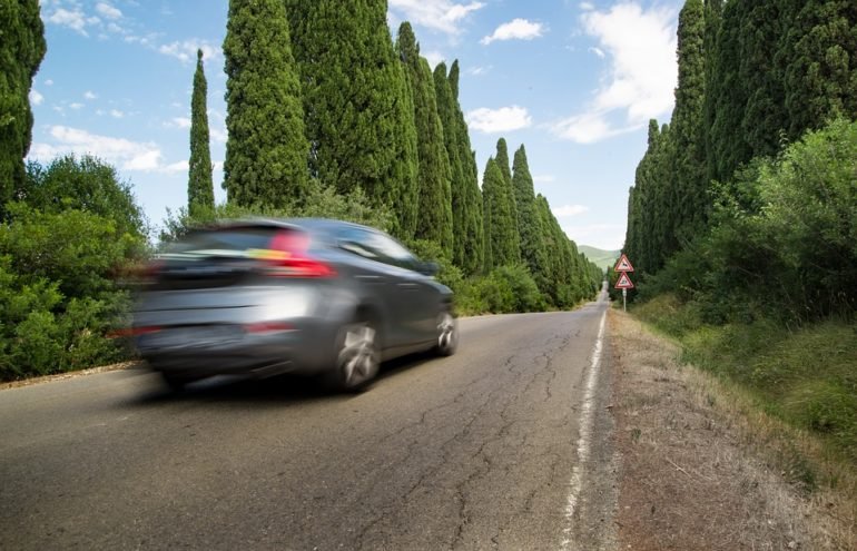 Blurred car driving on a road