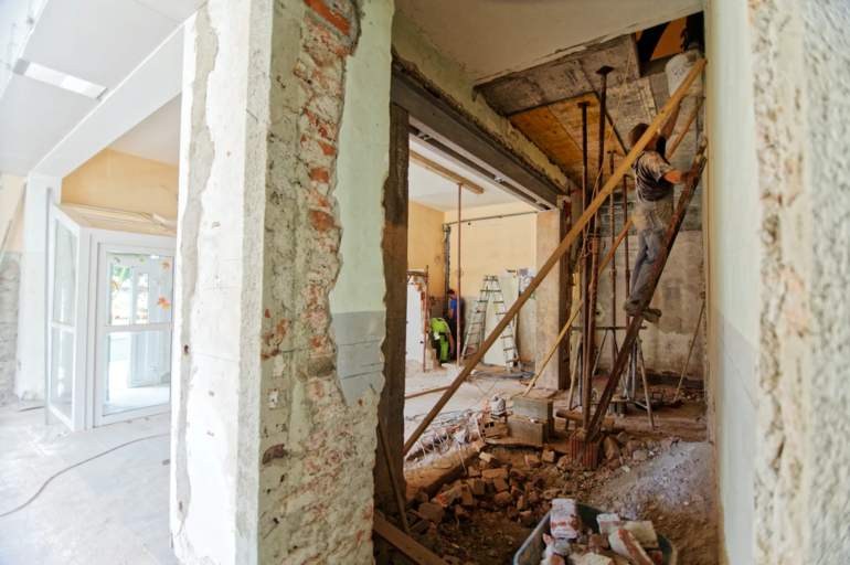 Workman on ladder working on house remodeling