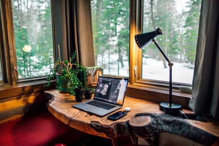 MacBook on a shaped dark wood desk