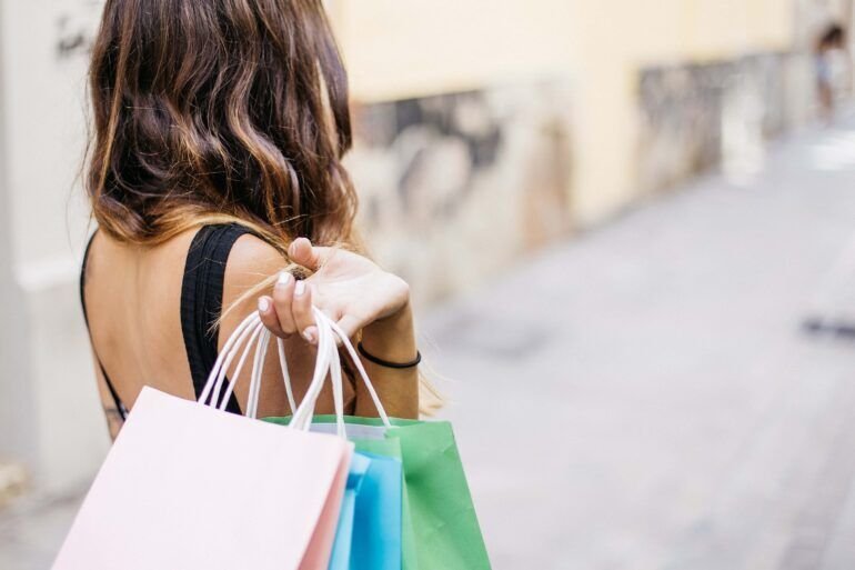 Woman carrying colourful paper shopping bags