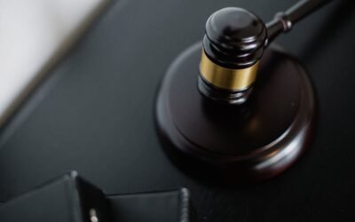 A closeup of a wooden gavel on a dark desk