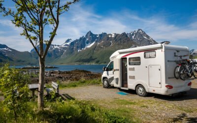 A rv parked on a gravel road next to a lake