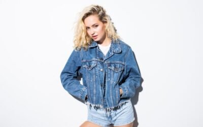 A woman wearing a denim jacket an jean shorts