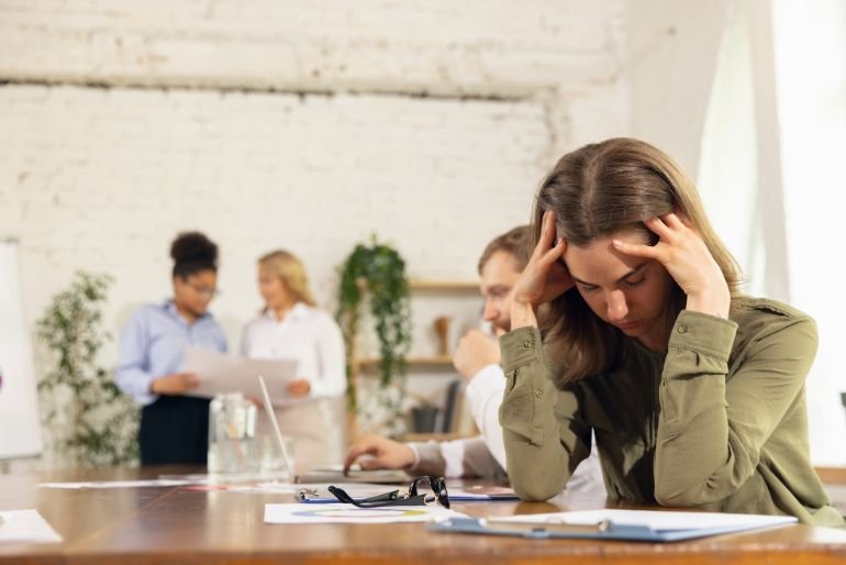 Stressed looking woman holding her head in her hands