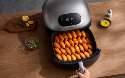 A person opening an air fryer drawer filled with food