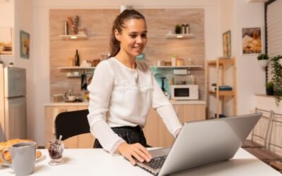 A woman working on a laptop set on a kitchen counter