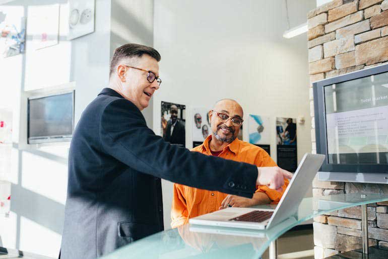 A person pointing to a laptop screen